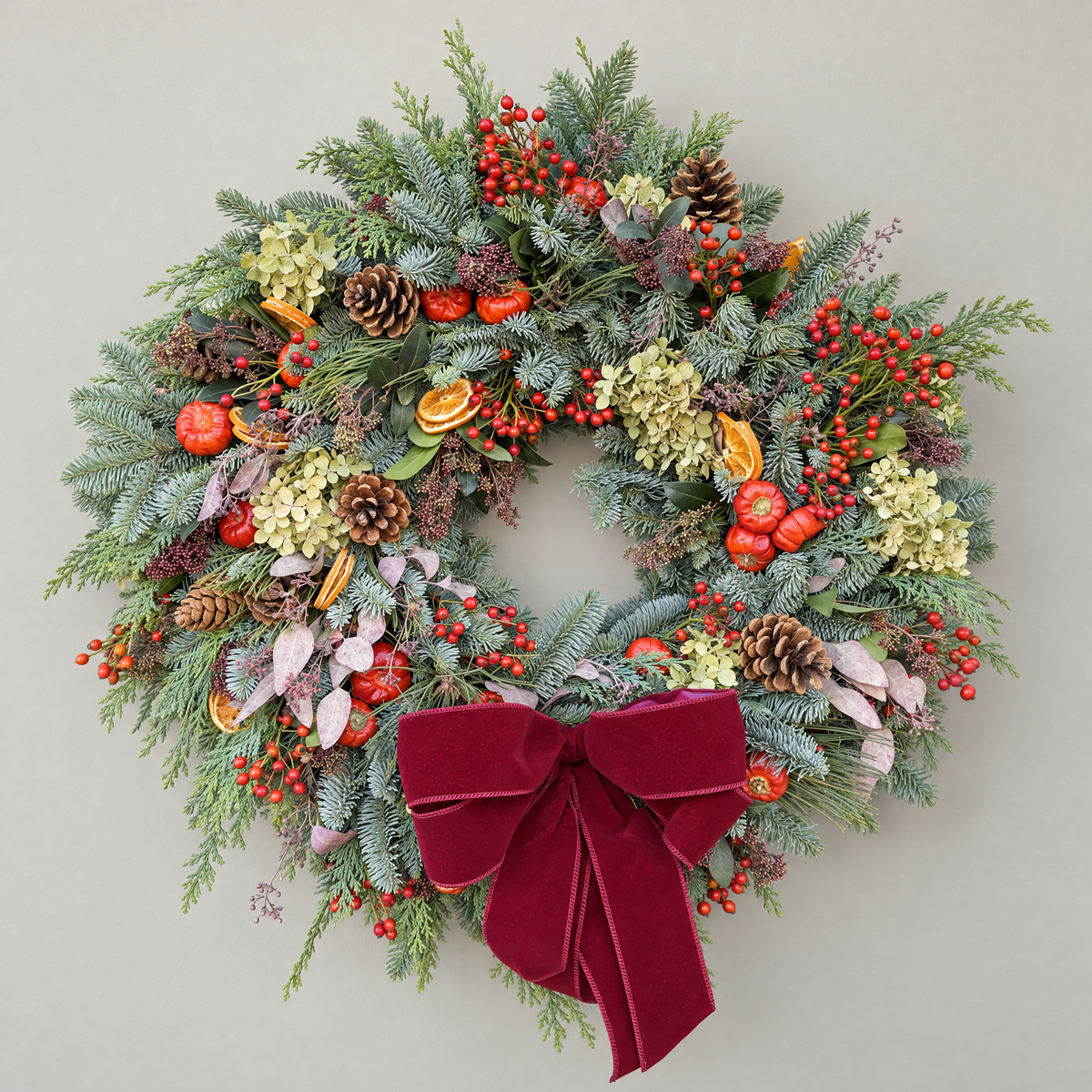 Winter Hedgerow Christmas wreath with noble fir, red rosehips, orange slices and a burgundy velvet bow