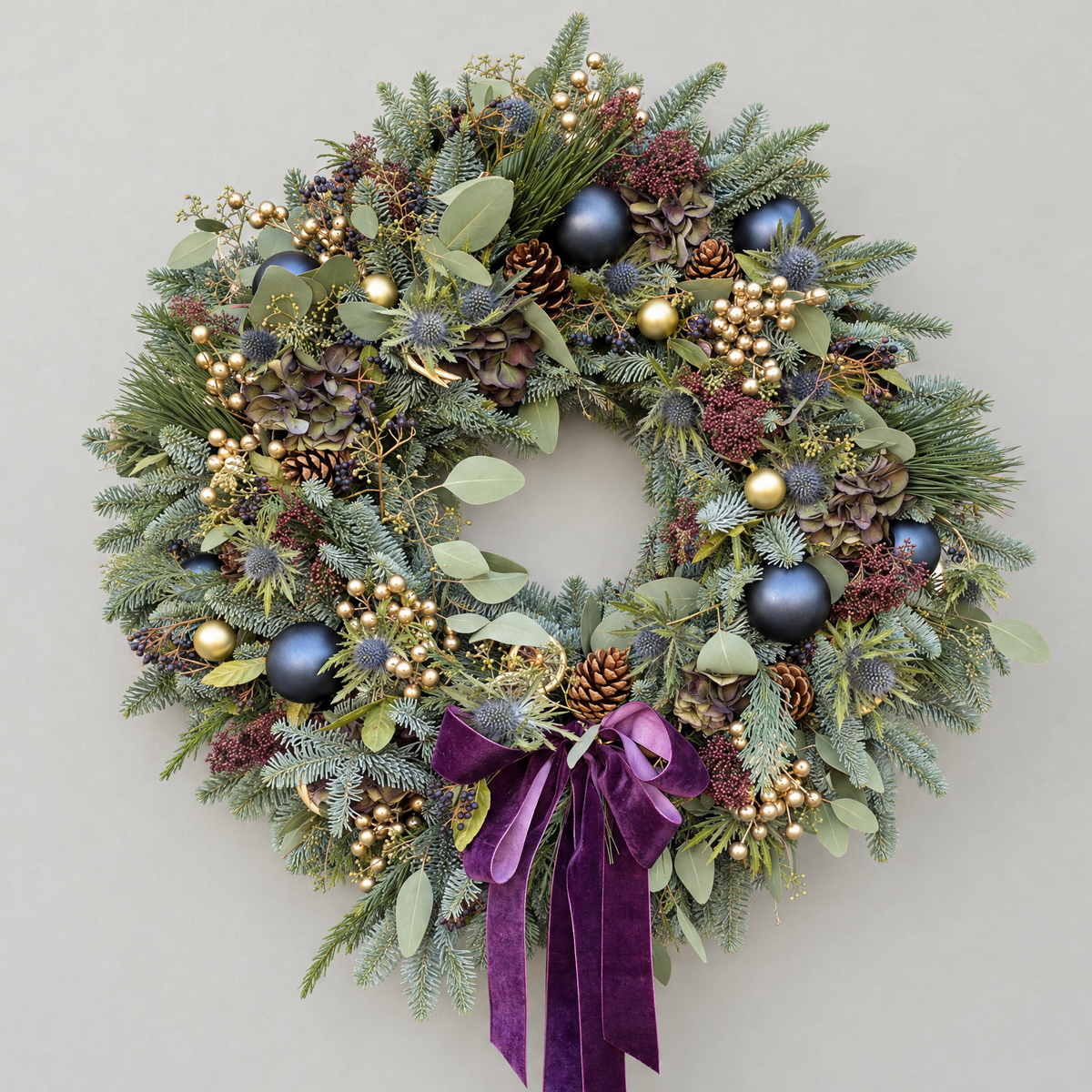 Sapphire Gilt Christmas wreath with navy and gold baubles, gold berries, thistles and a plum velvet ribbon
