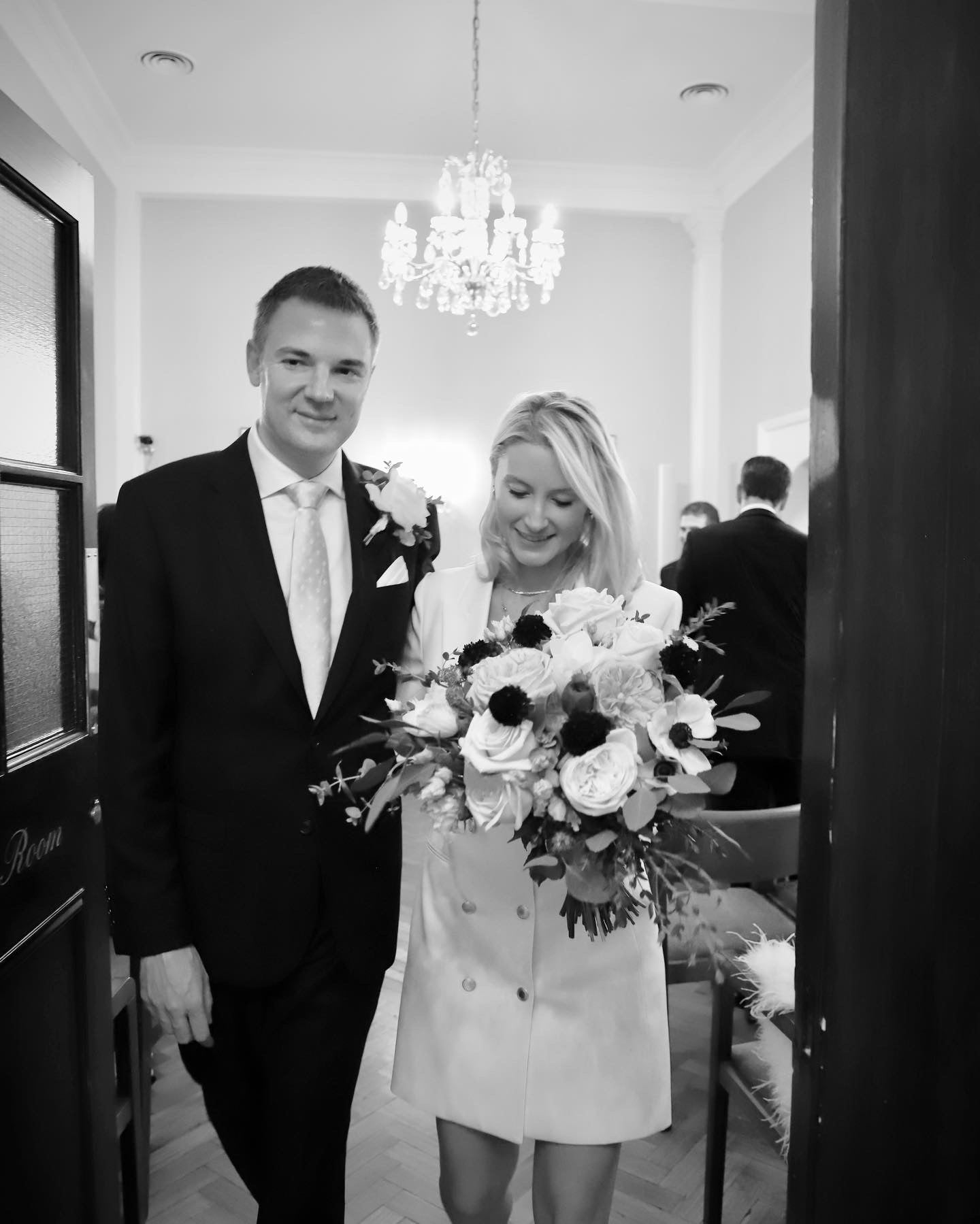 Bride and groom at ceremony doorway with chandelier