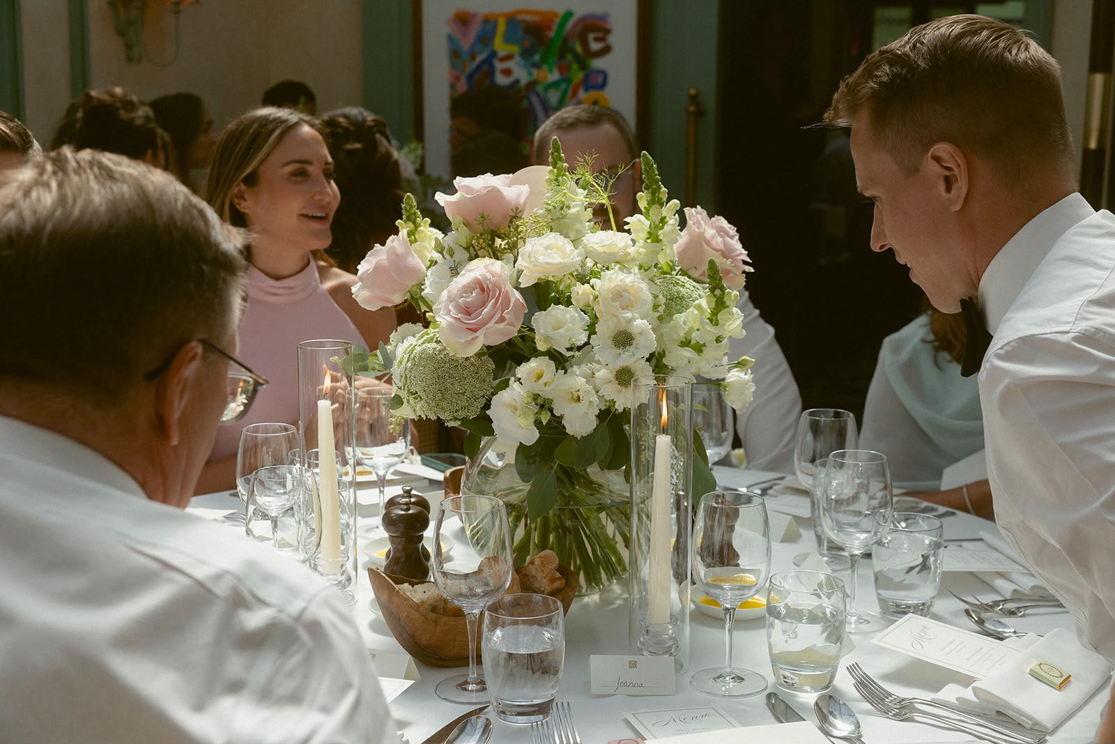 Wedding reception table with pink and white floral centrepiece