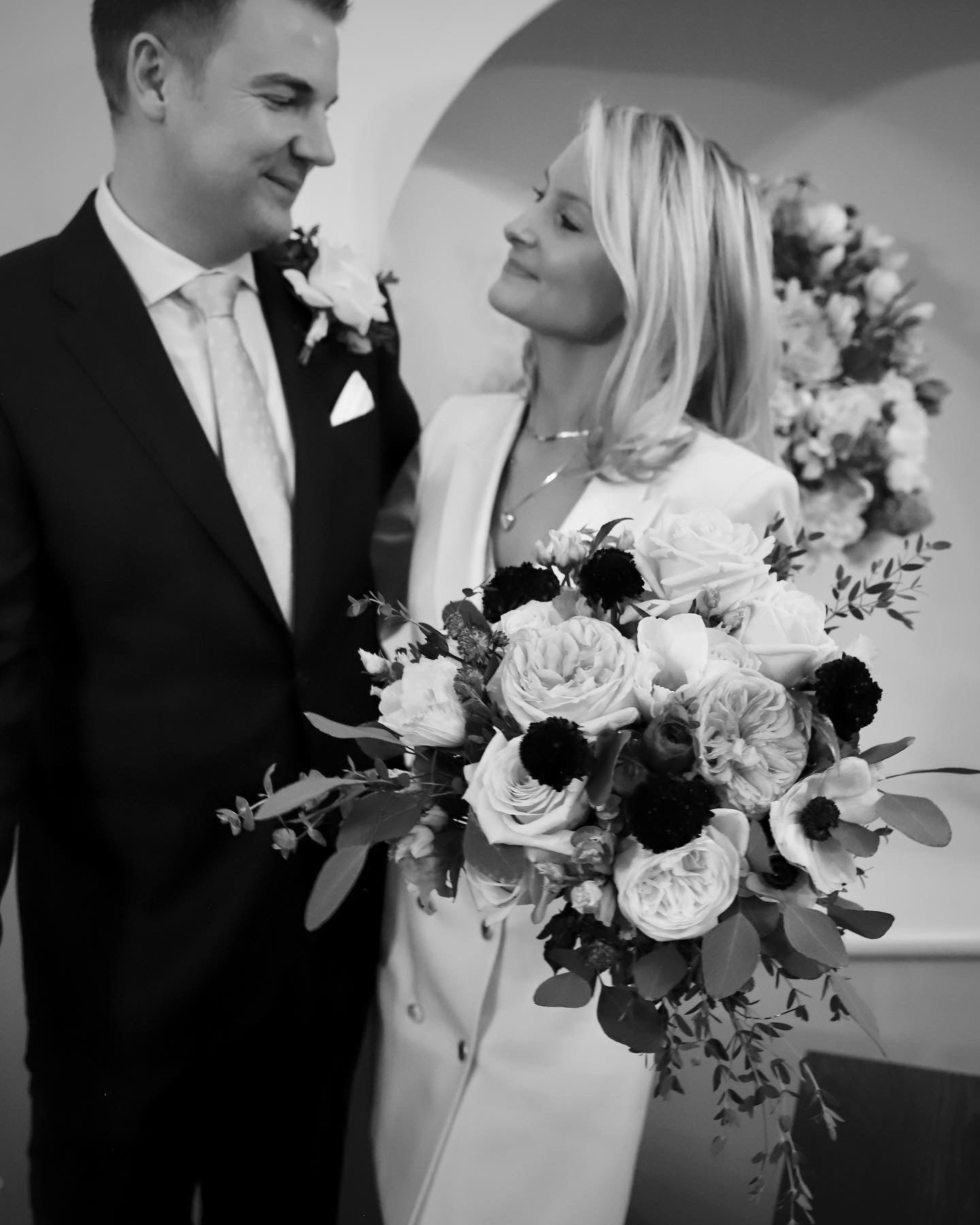 Couple gazing at each other with garden rose bouquet