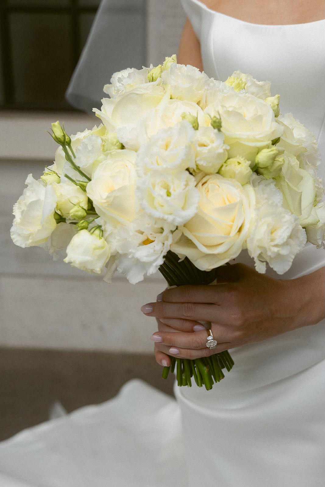 Close-up of white cream bridal bouquet with engagement ring