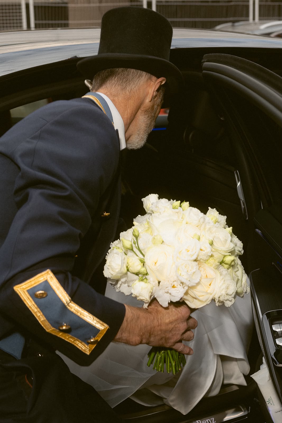 Hotel doorman presenting white bridal bouquet